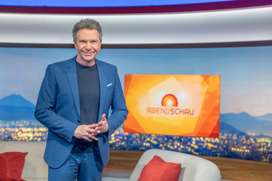 Roman Röll steht mit zusammengelegten Händen im Abendschau-Studio