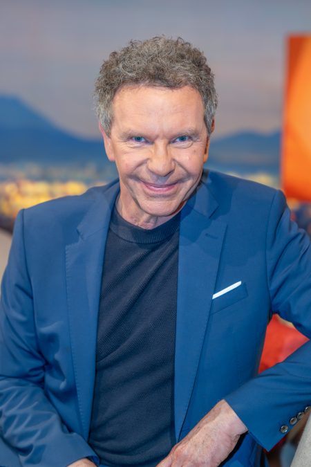 Hochformatporträt von Roman Röll im blauen Anzug